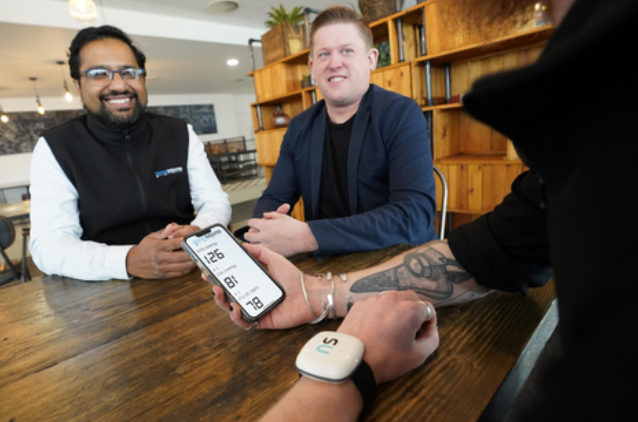 CEO and co-founder Dave Hughes (at centre) with Novosound's ultrasound blood pressure monitor (Photo: Business Wire)